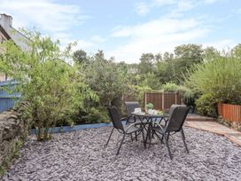 A garden with a table and chairs at Bryn Bach in Pentraeth