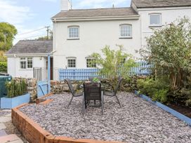 A garden with a table and chairs at Bryn Bach in Pentraeth