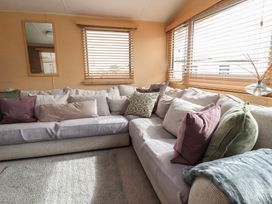 A living room with a sofa and pillows at Caravan 596 in Prestatyn