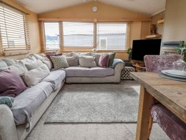 A living room with a sofa and television at Caravan 596 in Prestatyn