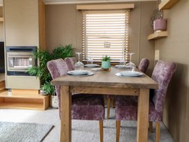 A dining room with a table and chairs at Caravan 596 in Prestatyn