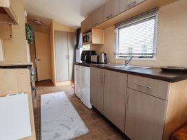 A kitchen with cabinets and appliances at Caravan 596 Prestatyn