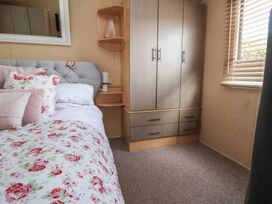 A bedroom with a bed and wardrobe at Caravan 596 Prestatyn