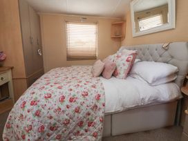 A bedroom with a bed and wardrobe at Caravan 596 Prestatyn