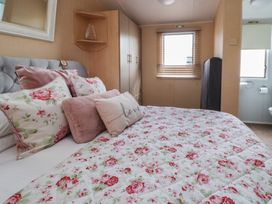 A bedroom with a bed and window at Caravan 596 Prestatyn