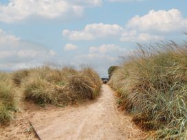 A dirt path between grass on a sunny day at Caravan 596 Prestatyn