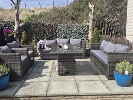 A garden with outdoor seating and a coffee table at Caravan 596 in Prestatyn