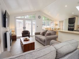 A living room with a sofa and dining area at Laughing Duck in Troutbeck Bridge