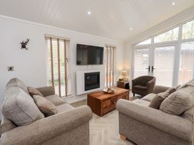 A living room with a sofa and television at Laughing Duck in Troutbeck Bridge