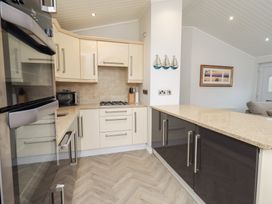 A kitchen with cabinets, a refrigerator, and a countertop at Laughing Duck in Troutbeck Bridge