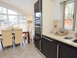 A kitchen with a dining table and chairs at Laughing Duck in Troutbeck Bridge