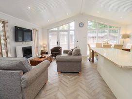 A living room with a sofa, armchair, and dining table at Laughing Duck in Troutbeck Bridge