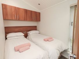 A bedroom with two single beds and a window at Laughing Duck in Troutbeck Bridge