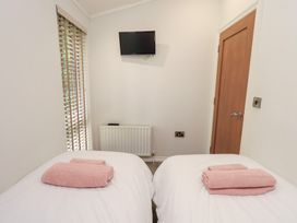 A bedroom with twin beds and a television at Laughing Duck in Troutbeck Bridge