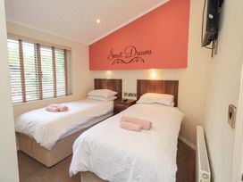A bedroom with twin beds and a television at Laughing Duck, Troutbeck Bridge