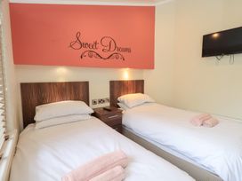 A bedroom with two beds and a television at Laughing Duck in Troutbeck Bridge