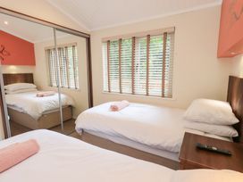 A bedroom with two beds and a wardrobe at Laughing Duck in Troutbeck Bridge
