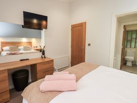 A bedroom with a bed and dressing table at Laughing Duck in Troutbeck Bridge