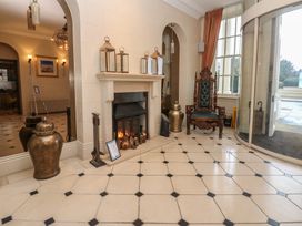 A lobby with a fireplace and armchair at Costal Lodge at Seaham Hall in Seaham