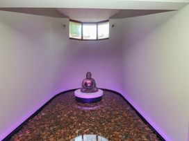 A spa with a Buddha statue on a pedestal surrounded by pebbles at Costal Lodge at Seaham Hall Seaham
