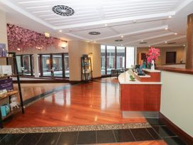 A lobby area with a reception counter and decorative shelves at Costal Lodge at Seaham Hall Seaham
