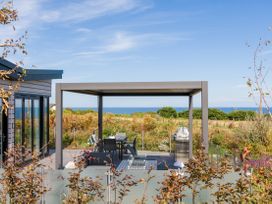 An outdoor area with a table and chairs under a pergola at Costal Lodge at Seaham Hall Seaham