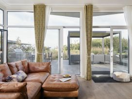 A living room with a brown couch and glass doors at Costal Lodge at Seaham Hall, Seaham