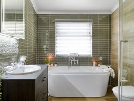 A bathroom with a bath tub, sink, and toilet at Costal Lodge at Seaham Hall in Seaham
