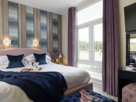 A bedroom with a bed and bedside table at Coastal Lodge at Seaham Hall Seaham