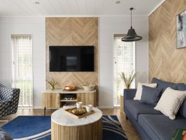A living room with a sofa and television at Costal Lodge at Seaham Hall in Seaham