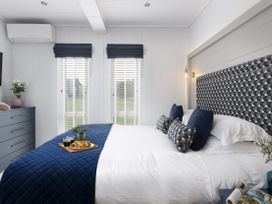 A bedroom with a bed and dresser at Costal Lodge at Seaham Hall, Seaham
