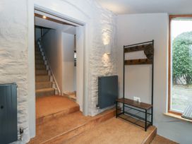 A hallway with stairs and a shelf at 3 bed property
