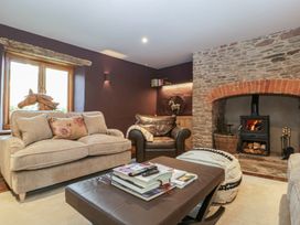 A living room with a wood stove and two sofas at 3 bed property 