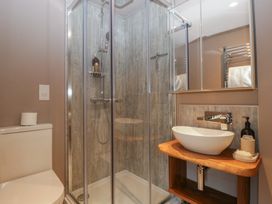 A bathroom with a shower, sink, toilet and mirror at 3 bed property