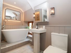 A bathroom featuring a bathtub, sink, toilet, and mirror at a 3 bed property