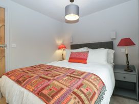 A bedroom with a bed, bedside lamps, and a patterned blanket at 3 bed property