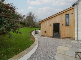 A garden with a gravel path leading to a wooden house at 3 bed property
