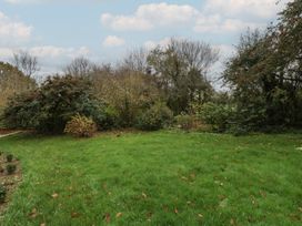 A garden with grass, bushes, and trees at 3 bed property 