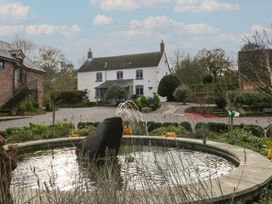 A garden with a fountain and a house at 3 bed property