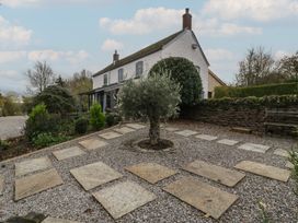 An outdoor view of a house with a garden and stepping stones in a gravel area at a 3 bed property