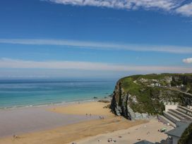 A beach with people and cabins at Higher Tower Road