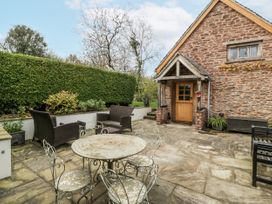 A garden with a stone patio and seating at 1 bed property in Usk