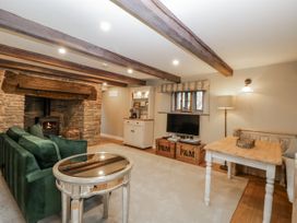 A living room with a sofa, fireplace, and television at 1 bed property in Usk