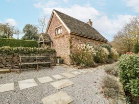 A garden with a stone house and pathway at 1 bed property in Usk