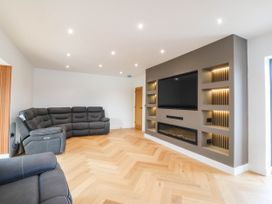 A living room with a sofa and television at Angorfa in Pentraeth