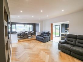 A living room with a sofa and a dining area at Angorfa in Pentraeth