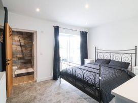 A bedroom with a bed and nightstands at Angorfa in Pentraeth