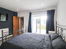 A bedroom with a bed and television at Angorfa in Pentraeth