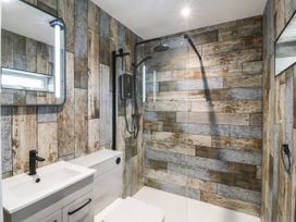 A bathroom with a sink and shower at Angorfa in Pentraeth