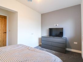A bedroom with a dresser and television at Angorfa in Pentraeth